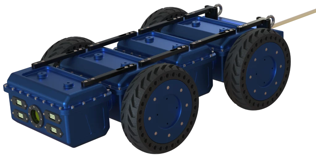 Rendu 3D du robot Modulo R développé par Sfynx Industry, un robot compact à quatre roues conçues pour la modularité et la mobilité en milieu industriel. Le châssis bleu est constitué de trois modules principaux reliés par des barres de renfort noires. À l’avant, une caméra centrale entourée de six projecteurs LED est intégrée pour la vision et l’éclairage. Les roues pleines à bande de roulement épaisse assurent la stabilité et la traction, tandis qu’une perche à l’arrière suggère une possibilité de remorquage ou de liaison avec d’autres modules.